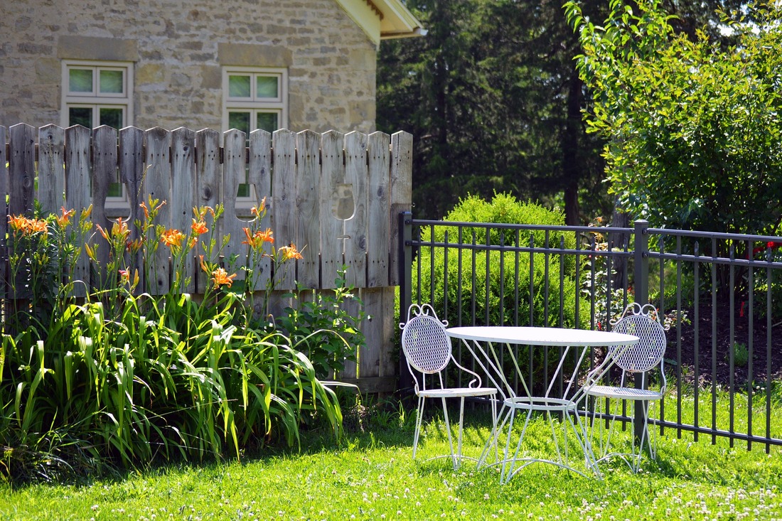 Yard setting with garden in the background and a table and two chairs